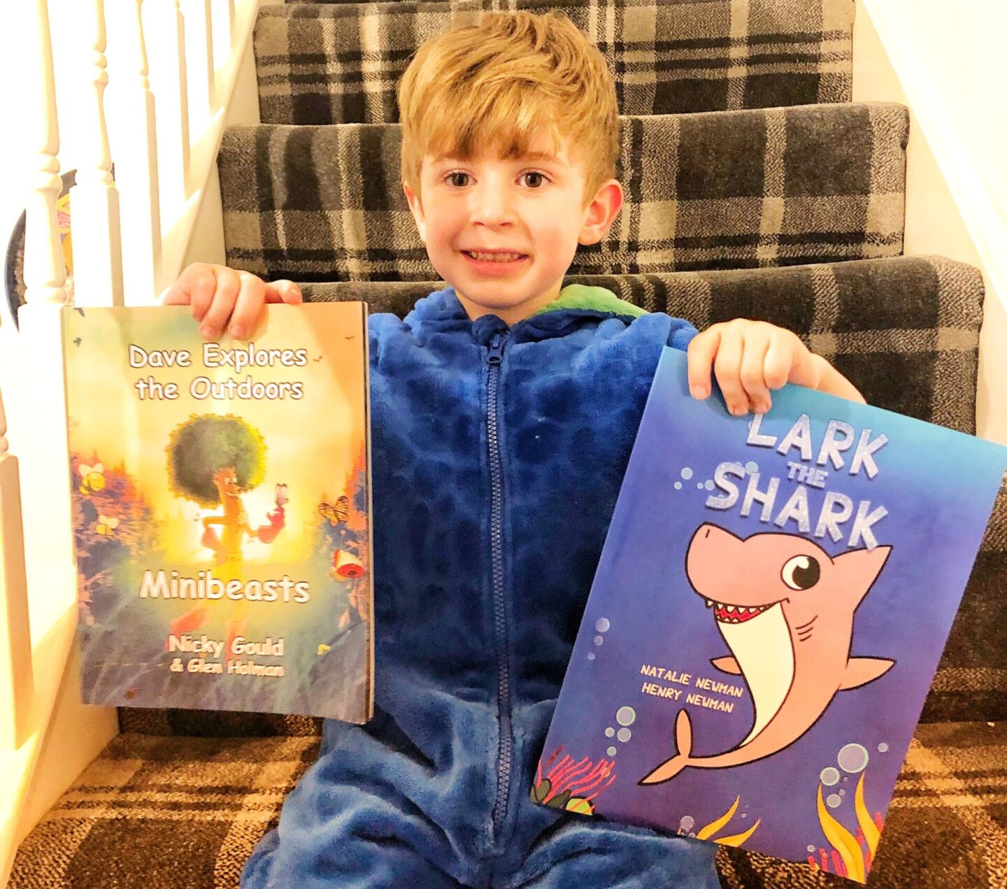 a small boy holding two books