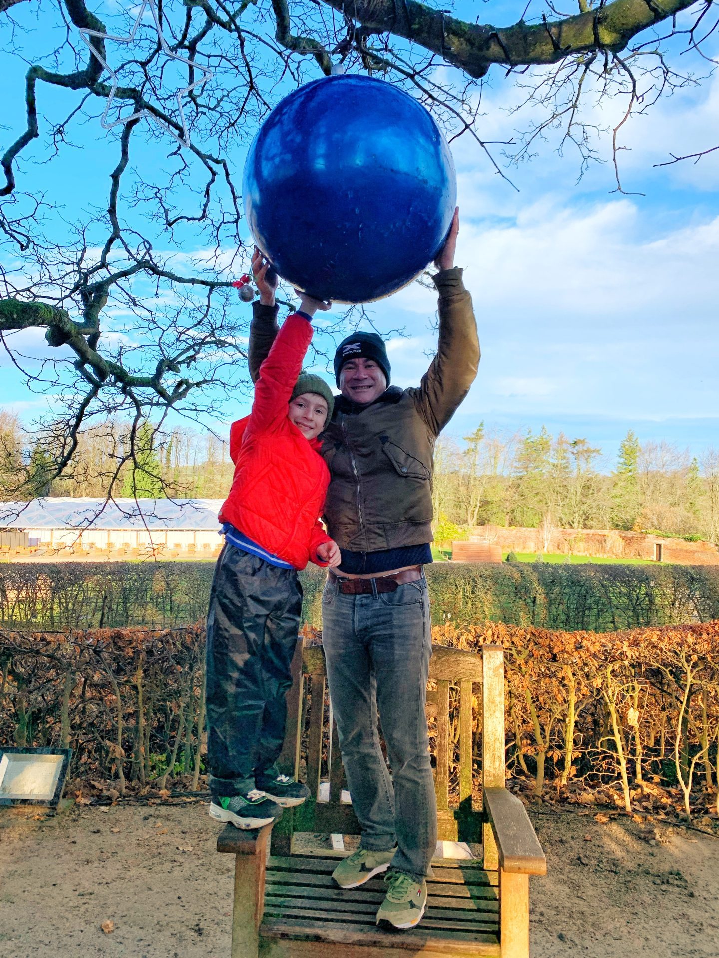a small boy and man holding a huge bauble