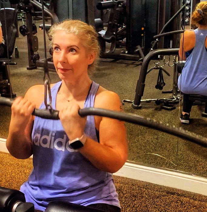 a midlife woman on the pulldown machine in the gym