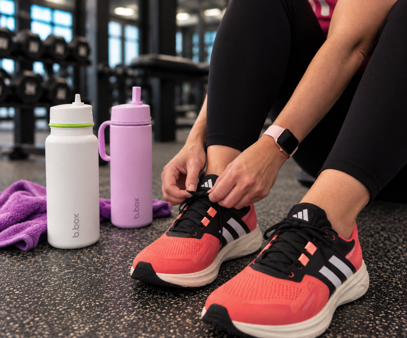 Woman tying Adidas trainers before a gym workout