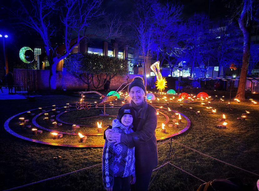 A woman and a child in front of a light installation